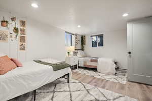 Bedroom with light hardwood / wood-style floors and a baseboard heating unit