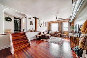 Living room featuring ceiling fan, a textured ceiling, and hardwood / wood-style flooring