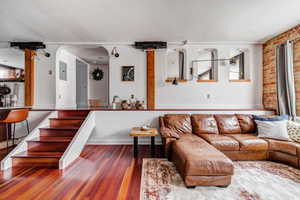 Living room with hardwood / wood-style floors and brick wall