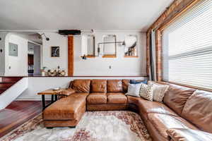 Living room with electric panel and hardwood / wood-style flooring