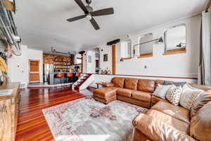 Living room featuring wood-type flooring and ceiling fan