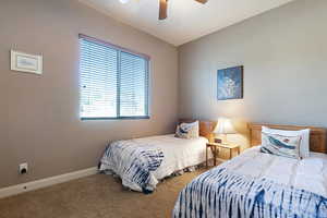 Carpeted bedroom featuring ceiling fan