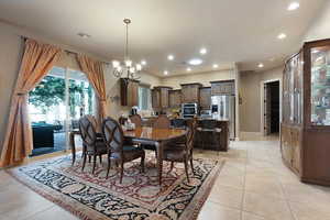 Dining space featuring light tile patterned flooring and a chandelier