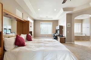 Carpeted bedroom with ensuite bathroom and a raised ceiling