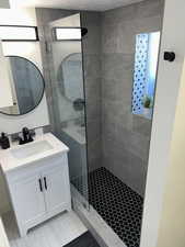 Bathroom featuring vanity and tiled shower