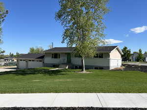 View of front of house with a garage and a front lawn