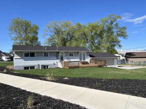 View of front of house with a front yard and a wooden deck