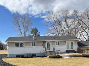 Back of house with a yard, a wooden deck, and central air condition unit