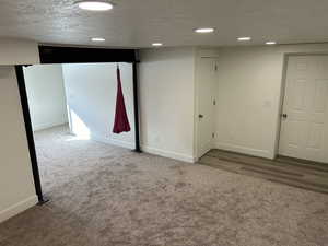 Basement with carpet floors and a textured ceiling