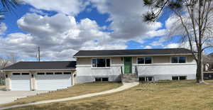 View of front of home with a front yard and a garage