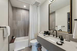 Full bathroom with shower / bath combo, vanity, and toilet