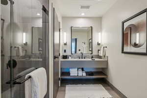 Bathroom with vanity, hardwood / wood-style flooring, and a shower with door