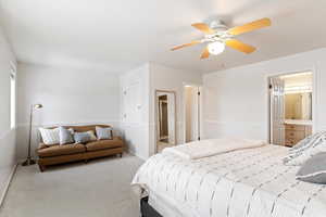 Carpeted bedroom with ceiling fan and ensuite bath