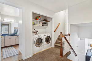 Washroom with independent washer and dryer, carpet floors, and sink