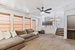 Living room featuring carpet floors and ceiling fan