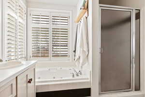 Bathroom featuring vanity and plus walk in shower