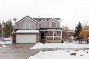 Front of property featuring a porch and a garage