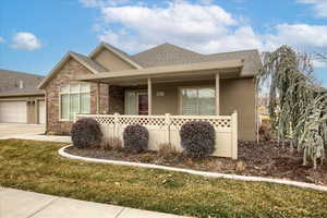 View of front facade featuring a garage, a porch, and a front yard