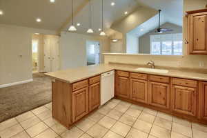 Kitchen featuring ceiling fan, sink, hanging light fixtures, kitchen peninsula, and white dishwasher