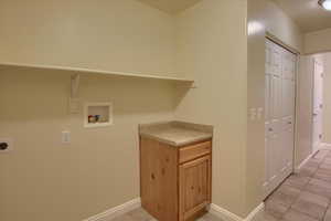 Laundry room featuring electric dryer hookup, light tile patterned floors, and hookup for a washing machine