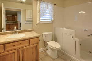 Bathroom with tile patterned flooring, vanity, and toilet