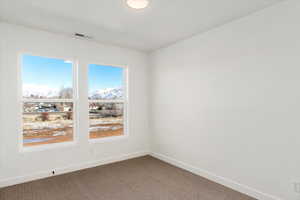 Empty room featuring carpet and a mountain view