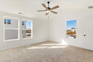 Carpeted spare room featuring ceiling fan and vaulted ceiling