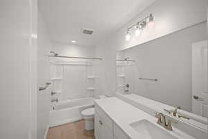 Full bathroom featuring tile patterned floors, vanity, toilet, and washtub / shower combination