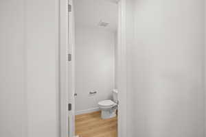 Bathroom featuring wood-type flooring and toilet