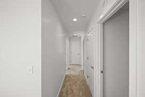 Hall featuring light colored carpet