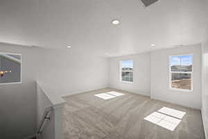 Spacious featuring a wealth of natural light and light colored carpet