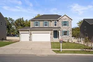 View of front facade featuring a garage and a front yard