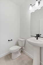 Bathroom with tile patterned floors, toilet, and sink