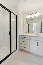 Bathroom with tile patterned floors, vanity, and walk in shower