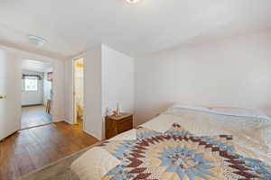 Bedroom with vaulted ceiling, wood-type flooring, and ensuite bath