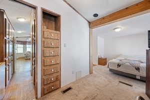 Bedroom featuring light carpet, beam ceiling, and a textured ceiling