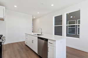 Kitchen featuring white cabinets, stainless steel appliances, a center island with sink, and sink