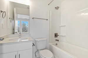 Full bathroom with vanity, shower / bathing tub combination, and toilet