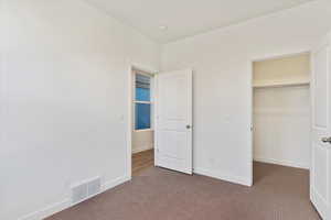 Unfurnished bedroom featuring carpet flooring and a closet