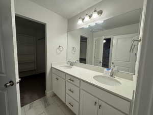 Bathroom with a textured ceiling and vanity