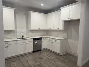 Kitchen featuring dark hardwood / wood-style flooring, white cabinetry, and dishwasher