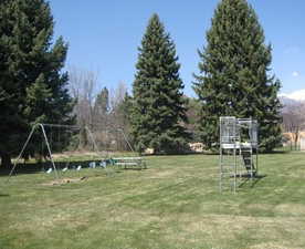 View of property's community with a playground and a yard