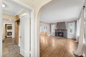 Unfurnished living room featuring a fireplace, light wood-type flooring, plenty of natural light, and stacked washer / dryer