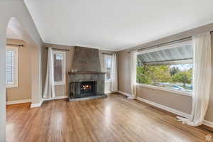 Unfurnished living room with light wood-type flooring and a tiled fireplace