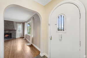 Foyer entrance with hardwood / wood-style flooring and a fireplace