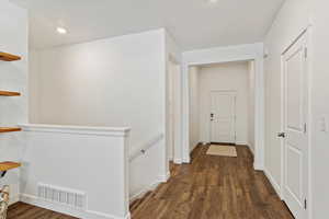 Hallway with dark hardwood / wood-style floors