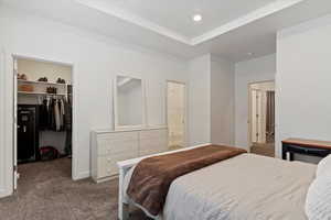 Bedroom featuring a walk in closet, ensuite bathroom, a closet, and carpet floors