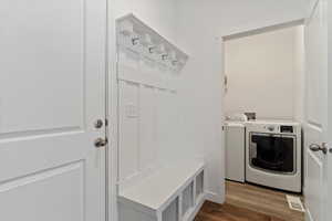 Mudroom featuring washer and dryer and dark wood-type flooring