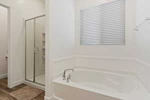 Bathroom featuring wood-type flooring and independent shower and bath