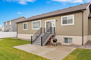 Rear view of house with a yard and a patio area